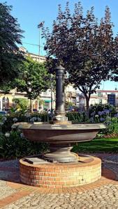 a fountain in a park with trees and buildings at Corte Soriano in Montenero di Bisaccia