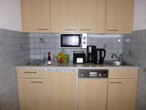 a kitchen with a sink and a microwave at Ferienwohnung Seeblick in Bodensdorf