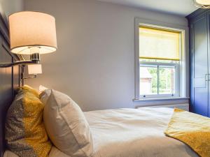 sypialnia z łóżkiem z lampką i oknem w obiekcie Forge Cottage w mieście Bradenham