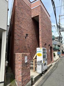 a brick building with a refrigerator on the side of it at 玉出105 wifi付 玉出駅から徒歩2分 地下鉄難波迄8分 in Osaka