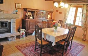 a dining room with a table and a fireplace at Holiday Home Menez Rooz - 01 in Pont-lʼAbbé