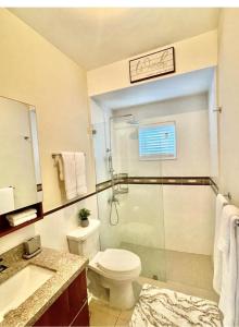 a bathroom with a shower and a toilet and a sink at Seashore Vacation Home, Oceanpointe, Lucea, Jamaica in Point