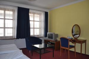 um quarto de hotel com uma cama e uma secretária com um espelho em Penzion u Coufalů em Loštice