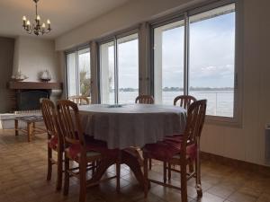 comedor con mesa, sillas y ventanas en Maison Locoal-Mendon, 3 pièces, 4 personnes - FR-1-397-71, en Locoal-Mendon