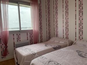 dwa łóżka pojedyncze w pokoju z oknem w obiekcie Maison 3 pièces, vue Ria d'Étel, jardin clos, proche mer et plages - FR-1-397-71 w mieście Locoal-Mendon