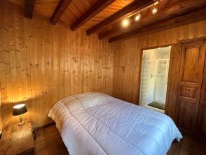 una camera con un letto su una parete in legno di Chalet La Clusaz, 5 pièces, 9 personnes - FR-1-437-103 a La Clusaz