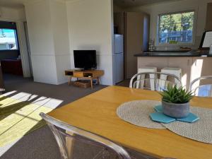 a kitchen and dining room with a table with a kitchen and a dining room at Relax on Rata, Cottage 1 in Twizel