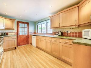 a large kitchen with wooden cabinets and wooden floors at Greenbank in Keswick