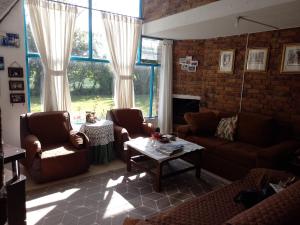 sala de estar con sofás, mesa y ventanas en Encantadora Finca San Gabriel Duitama, en Duitama