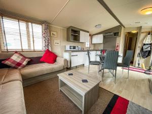 een woonkamer met een bank en een tafel bij Lovely Caravan With Decking Free Wifi At North Denes Caravan Park Ref 40145nd in Lowestoft