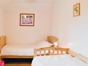 Habitación con 2 camas individuales y una foto en la pared. en Diggers Cottage, en Oxton