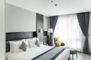 a hotel room with a bed and a chair at SureStay Hotel by Best Western Vientiane in Vientiane