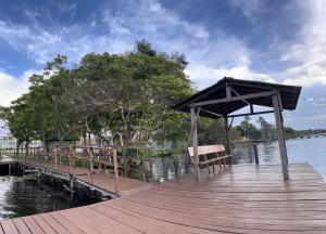 a wooden dock with a bench and a canopy on the water at Lençóis Confort - BL05-AP02 in Barreirinhas