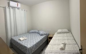 1 dormitorio con 2 camas y 1 perro en la cama en Lençóis Confort - BL05-AP02, en Barreirinhas