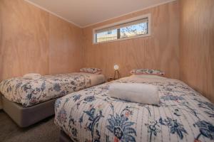 1 dormitorio con 2 camas y ventana en Starlight Townhouse en Twizel