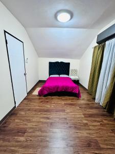 ein Schlafzimmer mit einem Bett mit einer rosa Decke in der Unterkunft 3 bedroom house Prestige Cabantian near Malls and Airport in Davao City