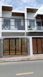 un edificio con dos puertas de garaje en el lateral de una calle en Khanh Thy Homestay Lagi, en La Gi