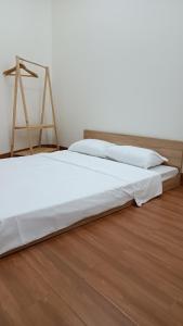 Bett in einem Zimmer mit einem Bettrahmen aus Holz in der Unterkunft Khanh Thy Homestay Lagi in La Gi