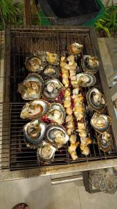 a bunch of oysters sitting on a grill at Khanh Thy Homestay Lagi in La Gi