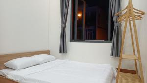 Bett in einem Zimmer mit Fenster und Leiter in der Unterkunft Khanh Thy Homestay Lagi in La Gi