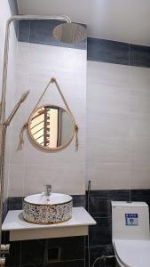 ein Badezimmer mit einem Waschbecken, einem Spiegel und einem WC in der Unterkunft Khanh Thy Homestay Lagi in La Gi