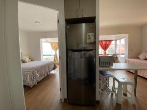 a kitchen with a refrigerator and a bedroom with a bed at Departamento con vista al mar in Viña del Mar