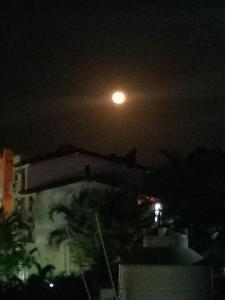 a moon in the sky over a city at night at Posada El Balcon in Rincon de Guayabitos