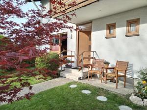 un patio con 2 sedie e un tavolo in un cortile di Ferienwohnung am Gänsbach a Grassau
