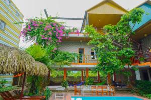 a building with a patio with tables and chairs and flowers at Phong Nha Dawn Home in Phong Nha