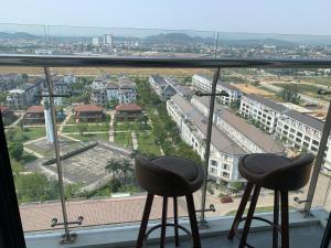 a view of a city from a window with two stools at Nera House in Hue