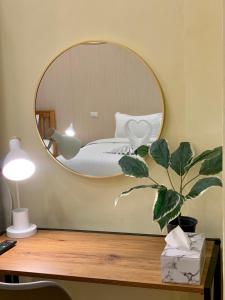 a mirror on a desk with a bed in a room at The Nimman Hotel - SHA Plus in Chiang Mai