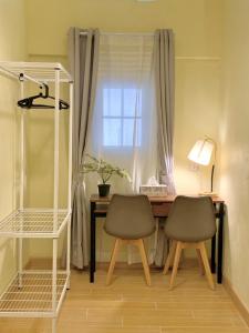 清邁的住宿－The Nimman Hotel - SHA Plus，窗前带两把椅子的桌子
