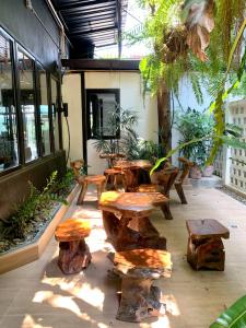 チェンマイにあるThe Nimman Hotel - SHA Plusの木製のテーブル、ベンチ、植物のあるパティオ