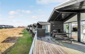 une maison avec une terrasse donnant sur un champ dans l'établissement Amazing Home In Frederikshavn With Kitchen, à Frederikshavn
