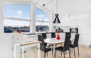 une cuisine avec une table et des chaises ainsi qu'une grande fenêtre dans l'établissement Amazing Home In Frederikshavn With Kitchen, à Frederikshavn