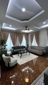 a living room with a couch and a table and chairs at Kamilia Homestay KB City Centre in Kota Bharu