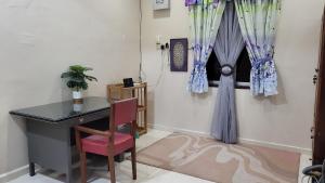 a desk and a chair in a room with a window at Sayf Homestay Kuala Terengganu in Kuala Terengganu