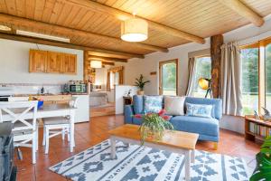 sala de estar con sofá azul y mesa en Herons Rise Vineyard Accommodation, en Kettering