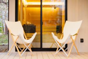two white chairs sitting on a porch at Hakuba Jolie Maison by Jade Villa in Hakuba