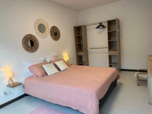 a bedroom with a large bed with pink sheets and pillows at La KAZA-De-LINE in Saint-Joseph