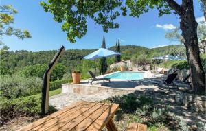 a villa with a pool and a picnic table and an umbrella at Amazing Home In Fayence With Wifi in Fayence