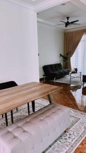 Kamilia Homestay KB City Centre في كوتا بْهارو: غرفة معيشة مع طاولة وأريكة