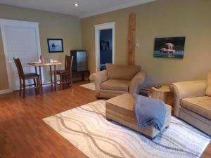 a living room with a couch and chairs and a table at Beaver Hut Bed And Breakfast in Port Alberni