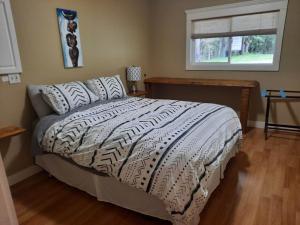 sypialnia z łóżkiem z białą kołdrą i oknem w obiekcie Beaver Hut Bed And Breakfast w mieście Port Alberni