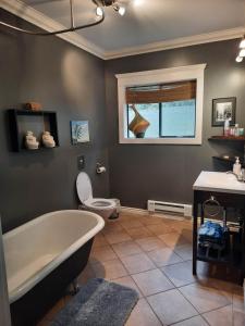 a bathroom with a tub and a toilet and a sink at Beaver Hut Bed And Breakfast in Port Alberni