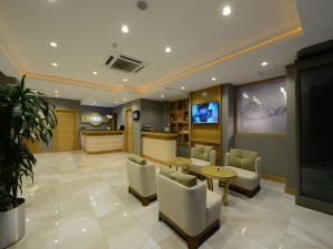 a lobby with chairs and tables and a tv at Hotel Olimpiyat in Istanbul