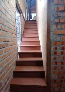 a stairway with a brick wall and brown steps at CHALET MADU KACA D'RUMAH BONDA RIVER VIEW Kuala Kangsar in Kampong Senawar