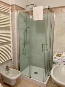 W łazience znajduje się szklana kabina prysznicowa i umywalka. w obiekcie Garibaldi18 w mieście Desenzano del Garda