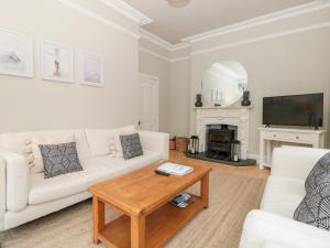 uma sala de estar com um sofá branco e uma mesa em St Saviours Reach em Dartmouth