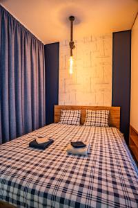 a bedroom with a bed with a plaid bedspread at Apartament Yacht Park Marina in Gdynia